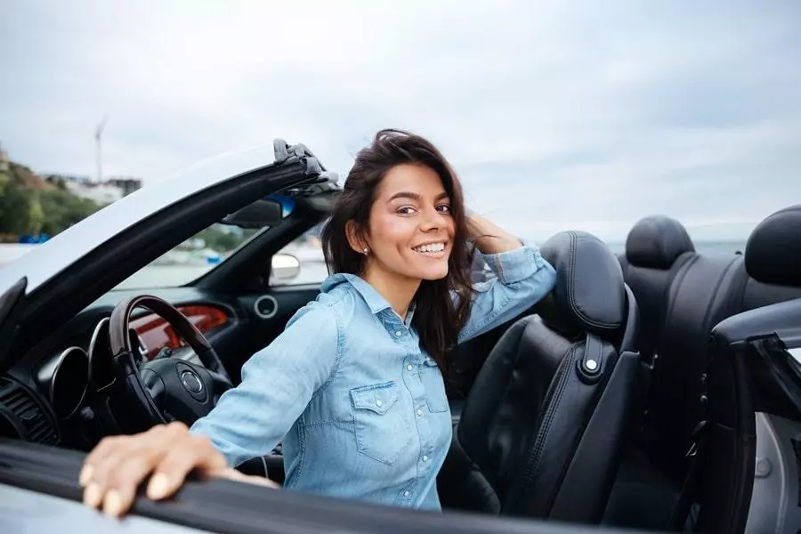 Xgraphicstock smiling young woman sitting inside her convertible car on beach BuspBhS3g.jpg.pagespeed.ic .X5QY5KM4Yz